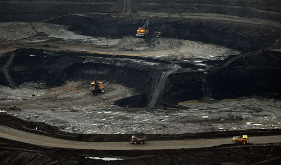 Veľké bagre zaťaženie nákladné automobily s ropných pieskov v bani Suncor neďaleko mesta Fort McMurray v provincii Alberta, Kanada 23. októbra 2009. Greenpeace vyzýva na ukončenie ťažby ropných pieskov v tejto oblasti vzhľadom na ich emisií skleníkových plynov a majú v poslednej dobe predstavený sit-ins, ktoré sa krátko zastavili výrobu v niekoľkých baniach.  Na odhadovaných 175 miliárd barelov, ropné piesky Alberta sú druhé najväčšie zásoby ropy na svete pred Saudskú Arábiu, ale oni boli zanedbané roky, s výnimkou miestnych firiem, kvôli vysokým nákladom ťažby.  Od roku 2000, vyletenia ceny ropy a lepšie metódy extrakcie urobili využívanie úspornejšie a majú prilákal niekoľko nadnárodných ropných spoločností ťažiť piesok.  AFP PHOTO / Mark RALSTON (Foto úveru by mal znieť MARK RALSTON / AFP / Getty Images)